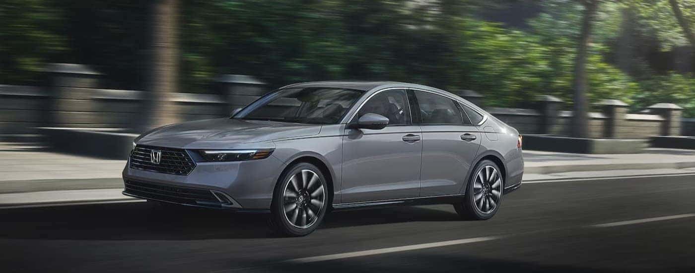 A gray 2025 Honda Accord Hybrid for Sale Near Rhome driving in a city.