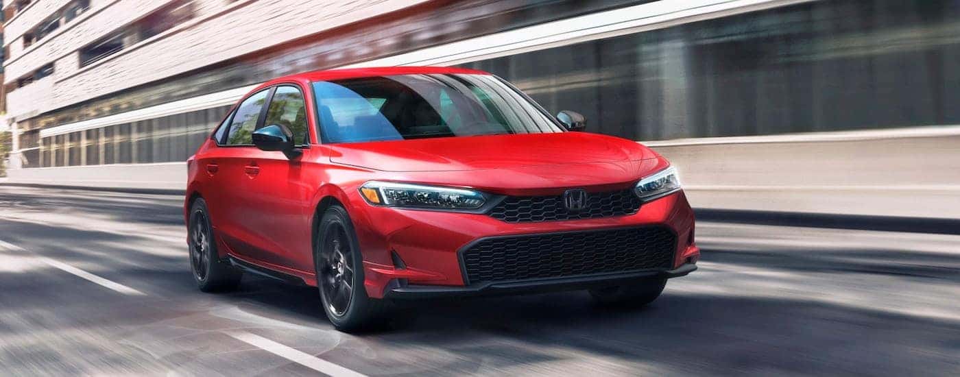 Red 2026 Honda Civic for sale near Rhome driving down an open road.