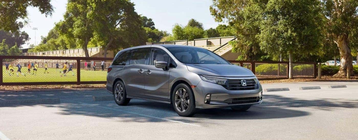 A gray 2024 Honda Odyssey Elite parked near a soccer field