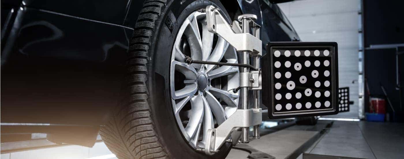 Black vehicle getting their tires aligned