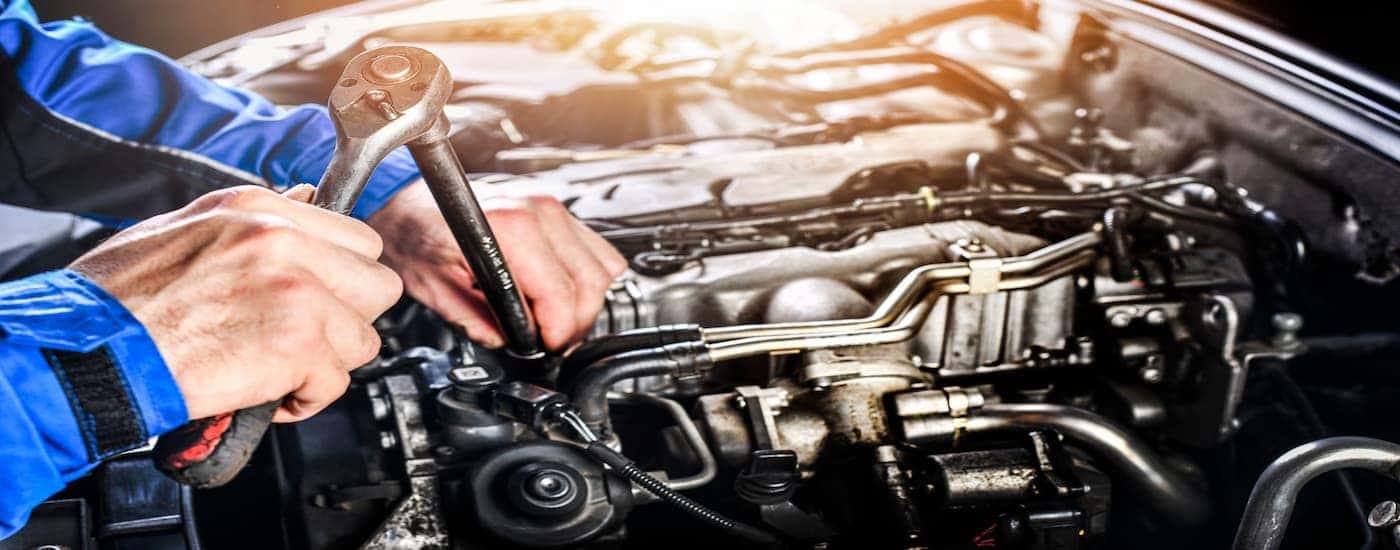 A mechanic working on the engine of a car at a Honda Service Center