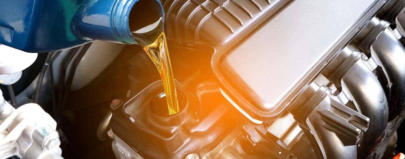 A technician adding oil to car engine