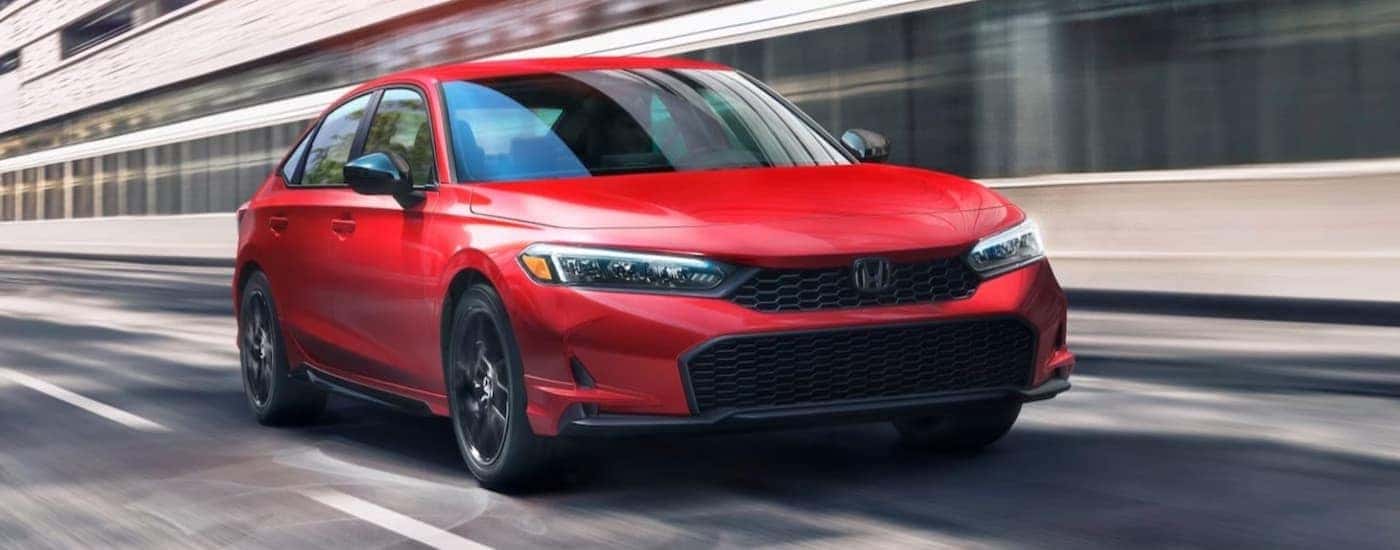 A red 2026 Honda Civic driving in a city.