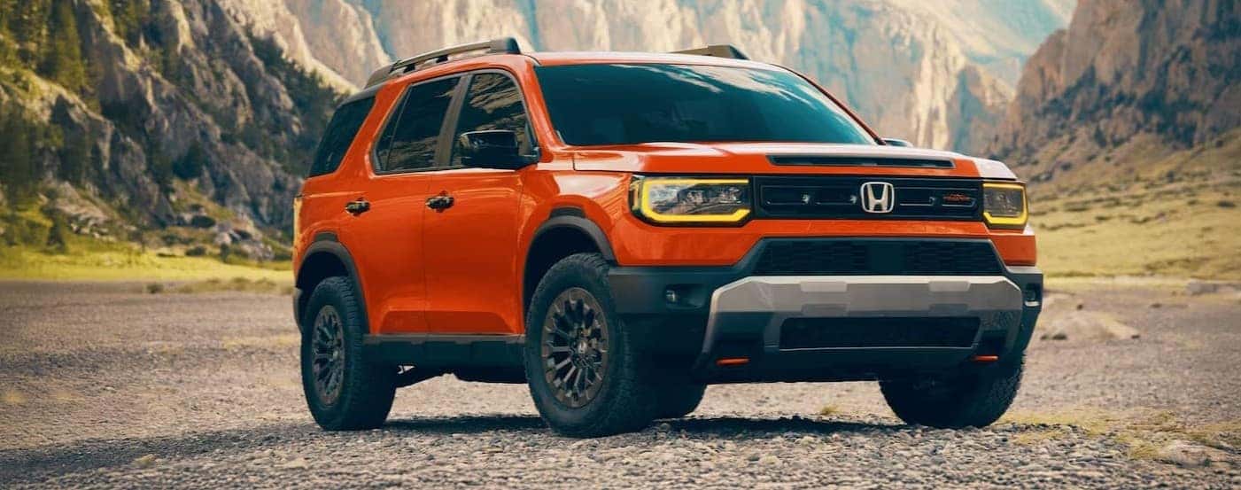 An orange 2026 Honda Passport TrailSport Elite parked offroad.