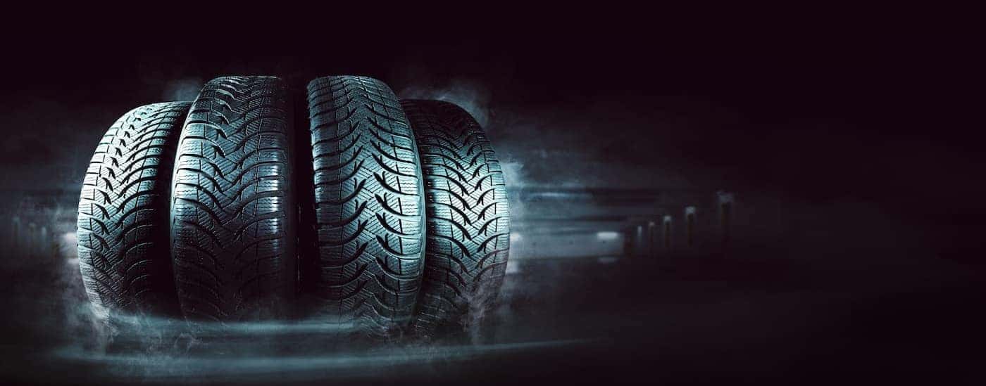 Four tires lined up side by side in the dark.