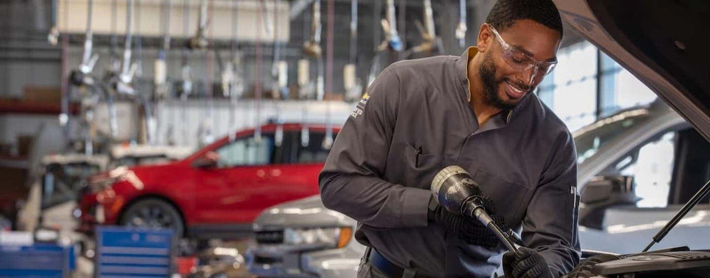 A technician working on SUVs for sale.