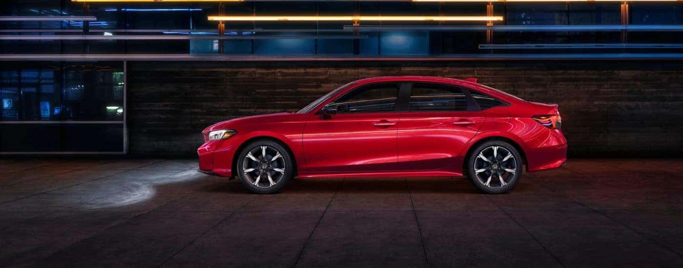 Red 2025 Honda Civic Hybrid ST from the side in a city