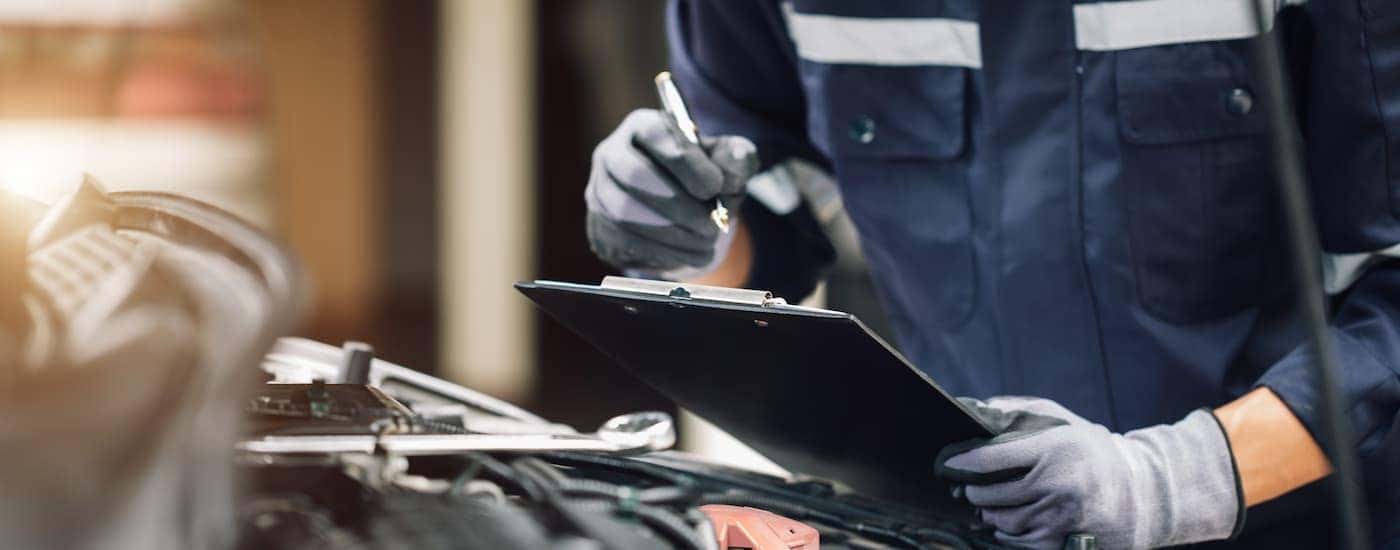 A mechanic holding a clipboard after running diagnostics