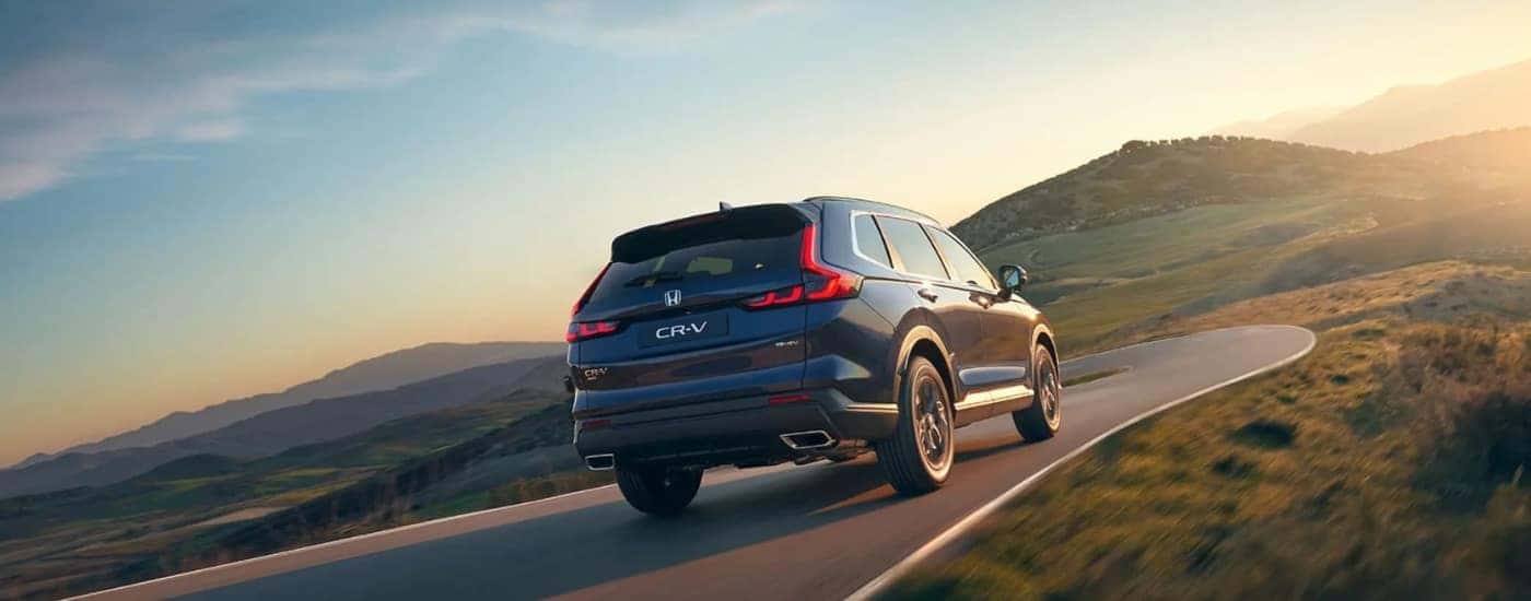 A blue 2025 Honda CR-V Hybrid driving on a highway