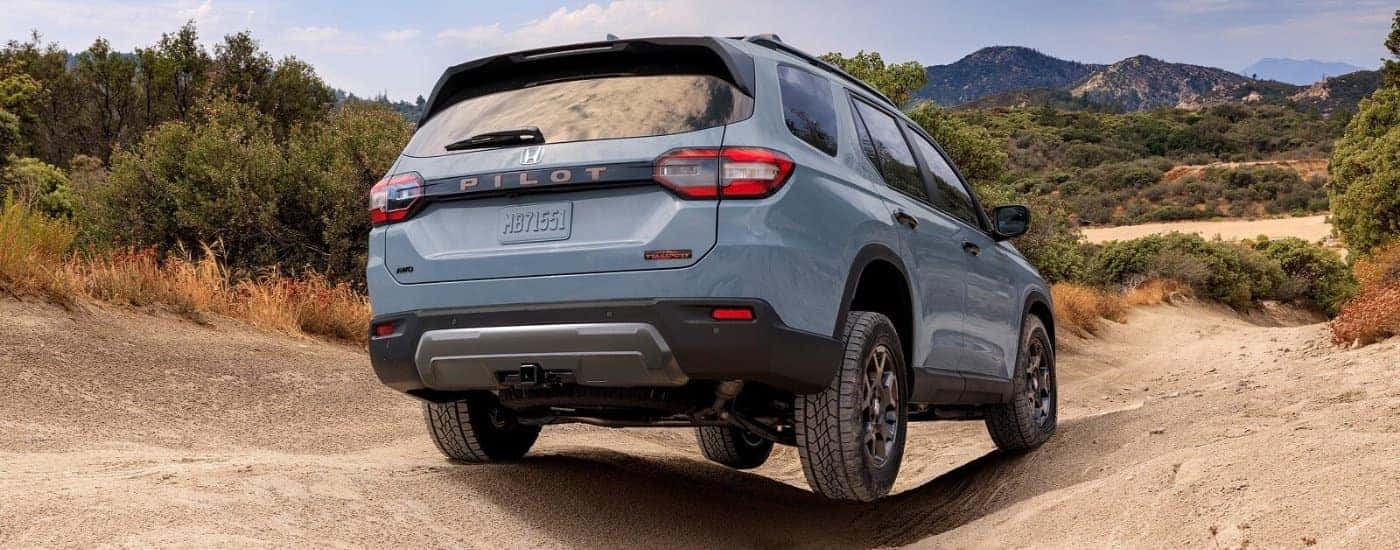 Blue 2026 Honda Pilot TrailSport driving off-road