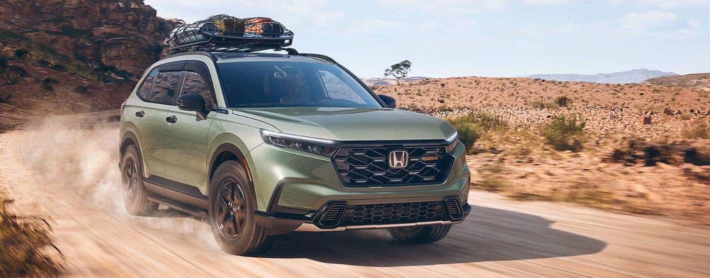 Green 2026 Honda CR-V with camping gear on the roof driving through the desert.