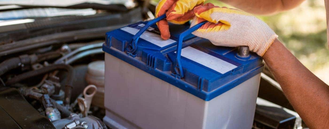 A car battery being installed by a technician.