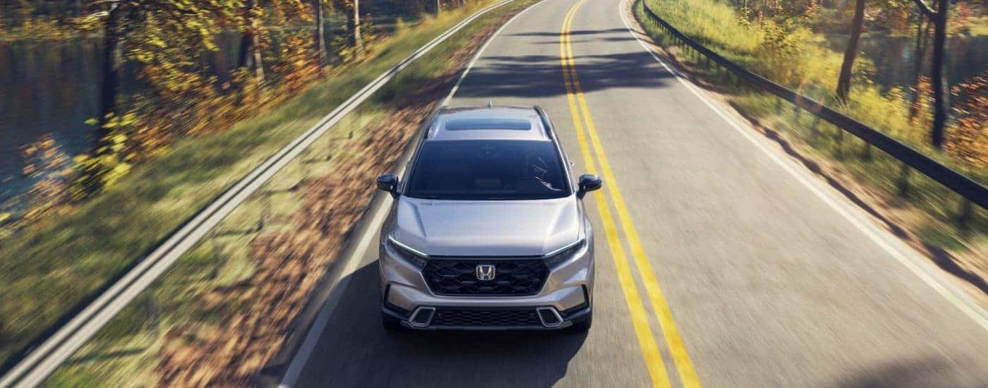 A silver 2026 Honda CR-V shown driving from the front on a paved road.