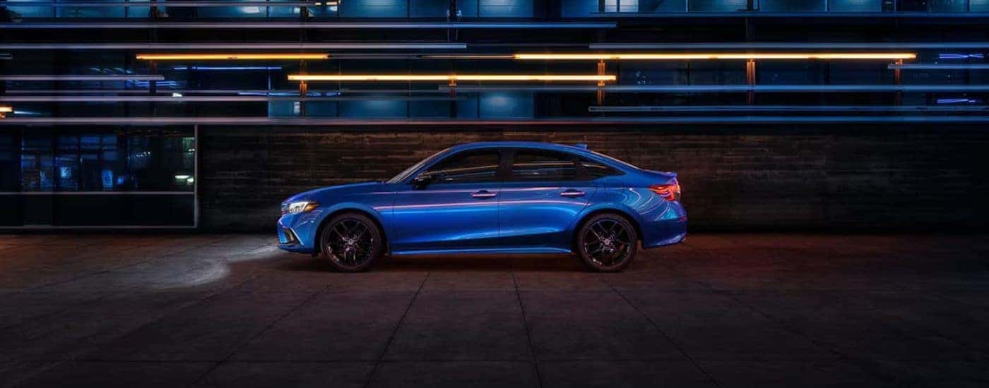 Blue 2022 Honda Civic with lights on driving at night