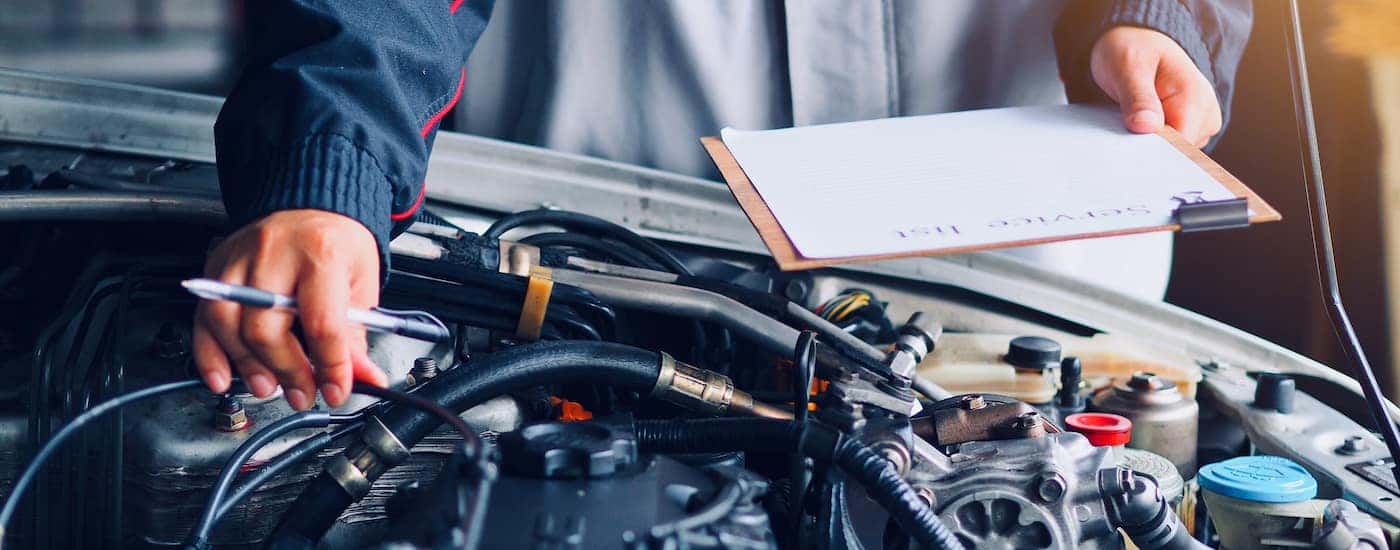 A mechanic performing an engine inspection on a vehicle.