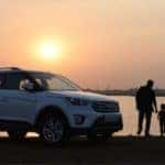A father and son are walking from their Hyundai to the lake at sunset.