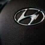 Silver Hyundai logo on a black steering wheel.