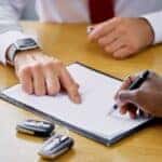 car salesman filling out paperwork