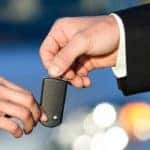 Woman Handing Over Car Keys to Salesman
