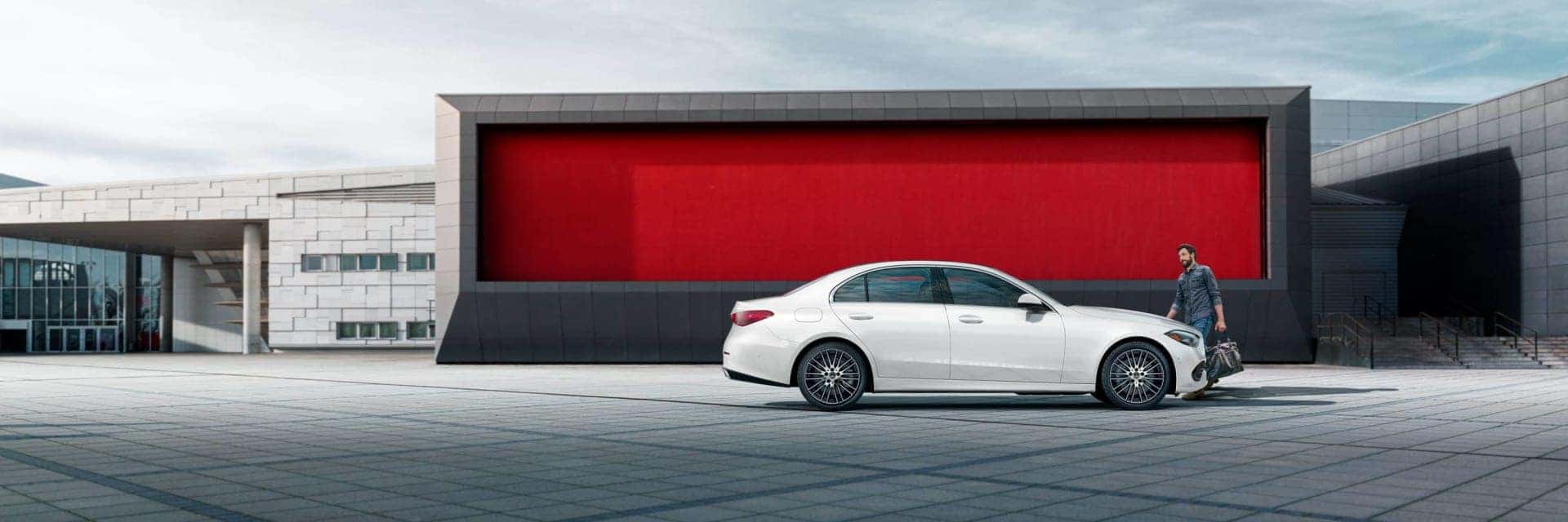man standing next to 2025 white mercedes-benz c class sedan