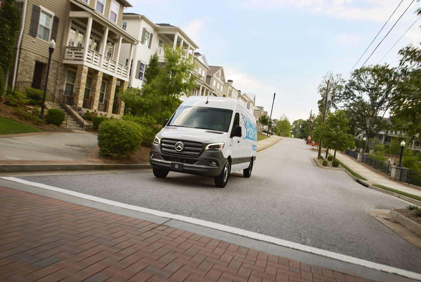 sprinter van driving down neighborhood street