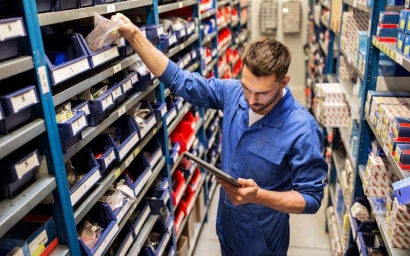 Auto mechanic or smith with tablet pc at workshop
