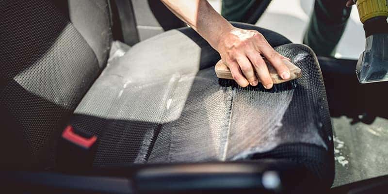 Scrubbing leather seats with brush