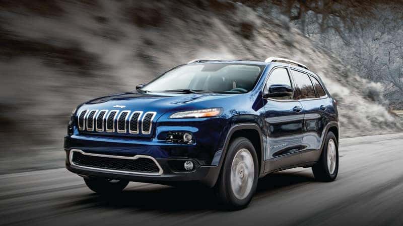 Jeep Selec-Terrain Traction Management System Explained A blue 2019 Jeep Cherokee driving through the mountains