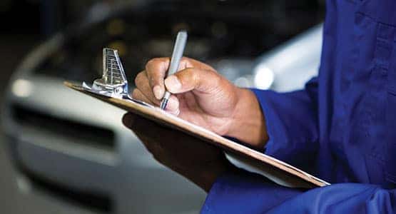 An auto service worker going through a checklist