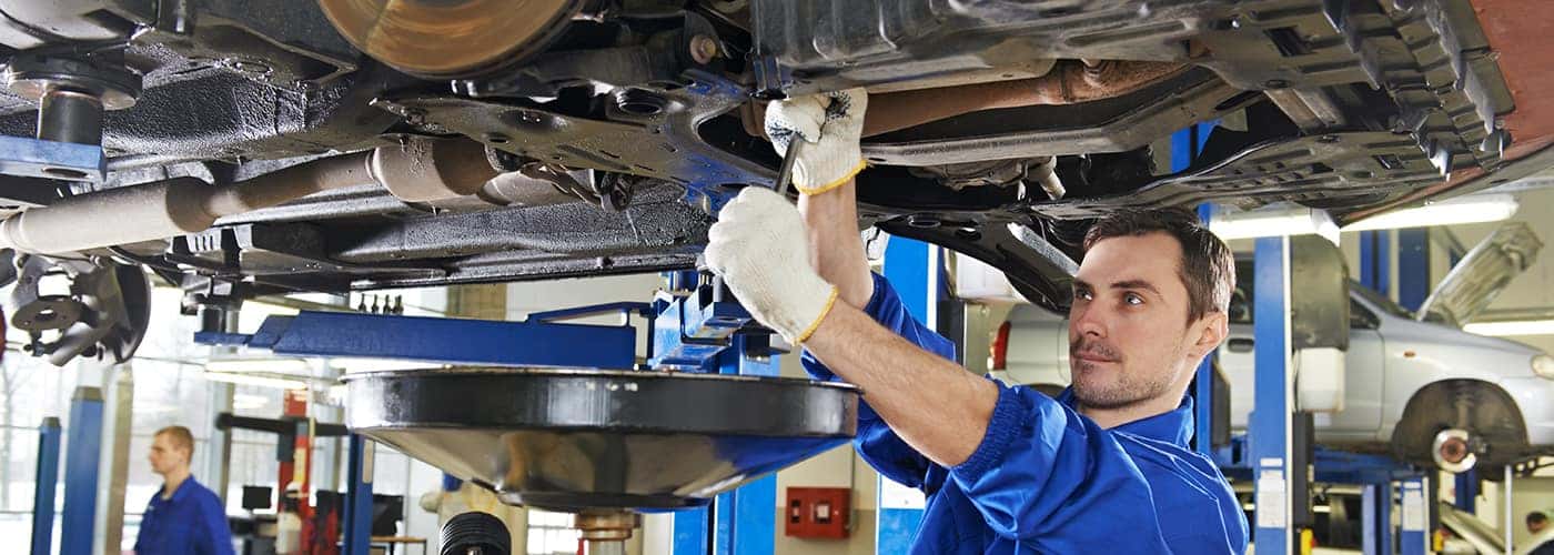 omul care lucrează sub mașină în Auto body shop