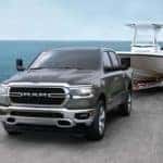 Front view of 2020 RAM 1500 towing boat in front of large body of water