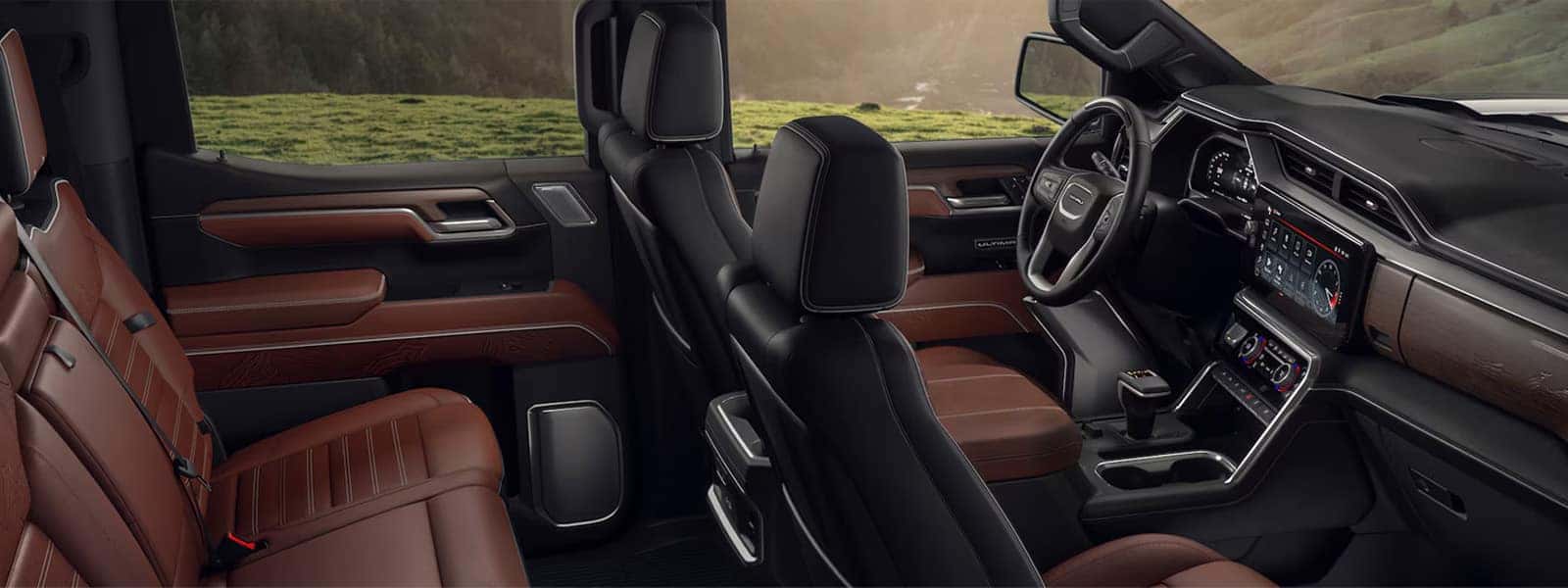 2026 GMC Sierra 1500 interior showing premium front cabin with large center touchscreen, digital driver display, and leather seating