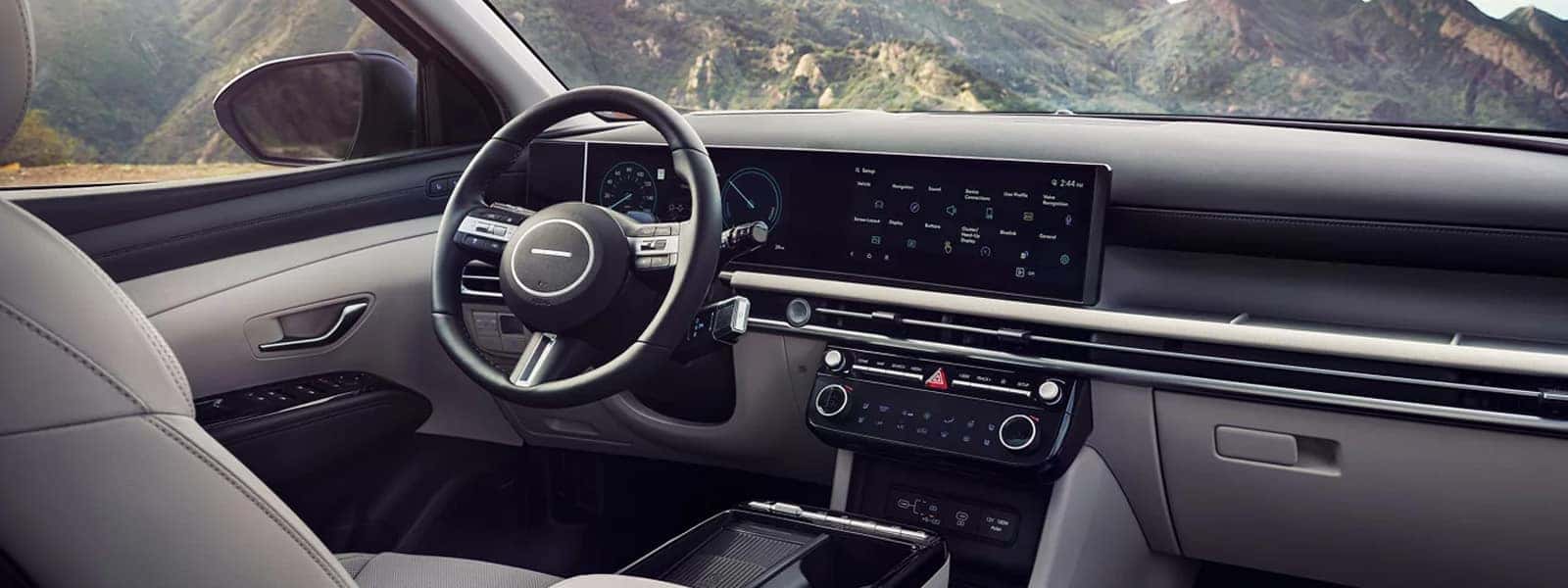 Front interior view of the Hyundai Tucson Hybrid highlighting the digital dashboard, touchscreen display, and modern cockpit layout.