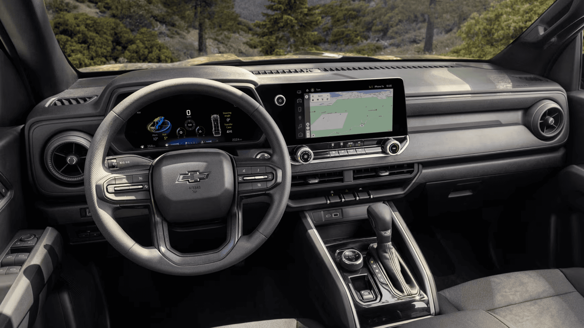 Chevy Colorado interior showing the steering wheel, digital instrument cluster, center touchscreen with navigation map, and center console