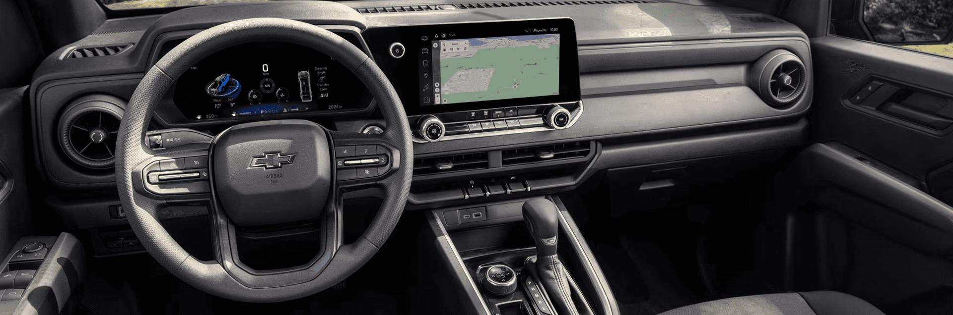 Chevy Colorado interior showing the steering wheel, digital instrument cluster, center touchscreen with navigation, and center console