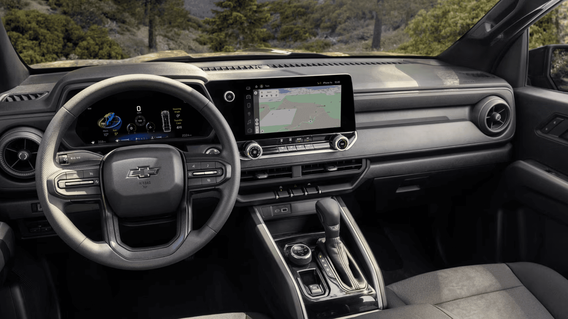 Chevy Colorado interior showing the steering wheel, digital gauge cluster, center touchscreen with navigation map, and center console