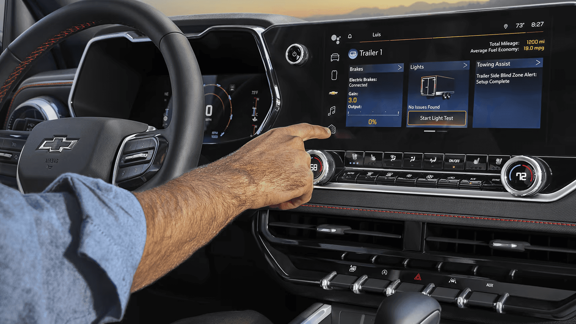 Driver using the Chevy Colorado infotainment screen to manage trailer lights and towing assist settings