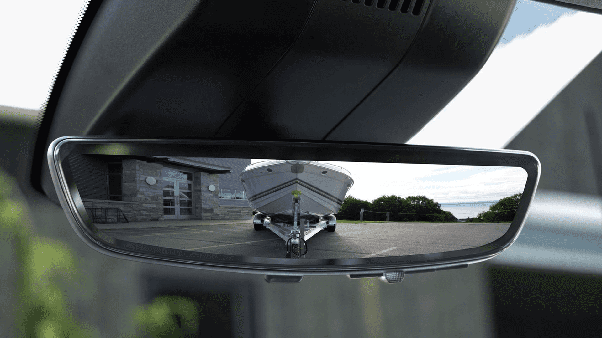 2026 Chevy Silverado HD rear camera mirror showing a clear rearward camera view of a boat trailer aligned behind the truck for trailering visibility