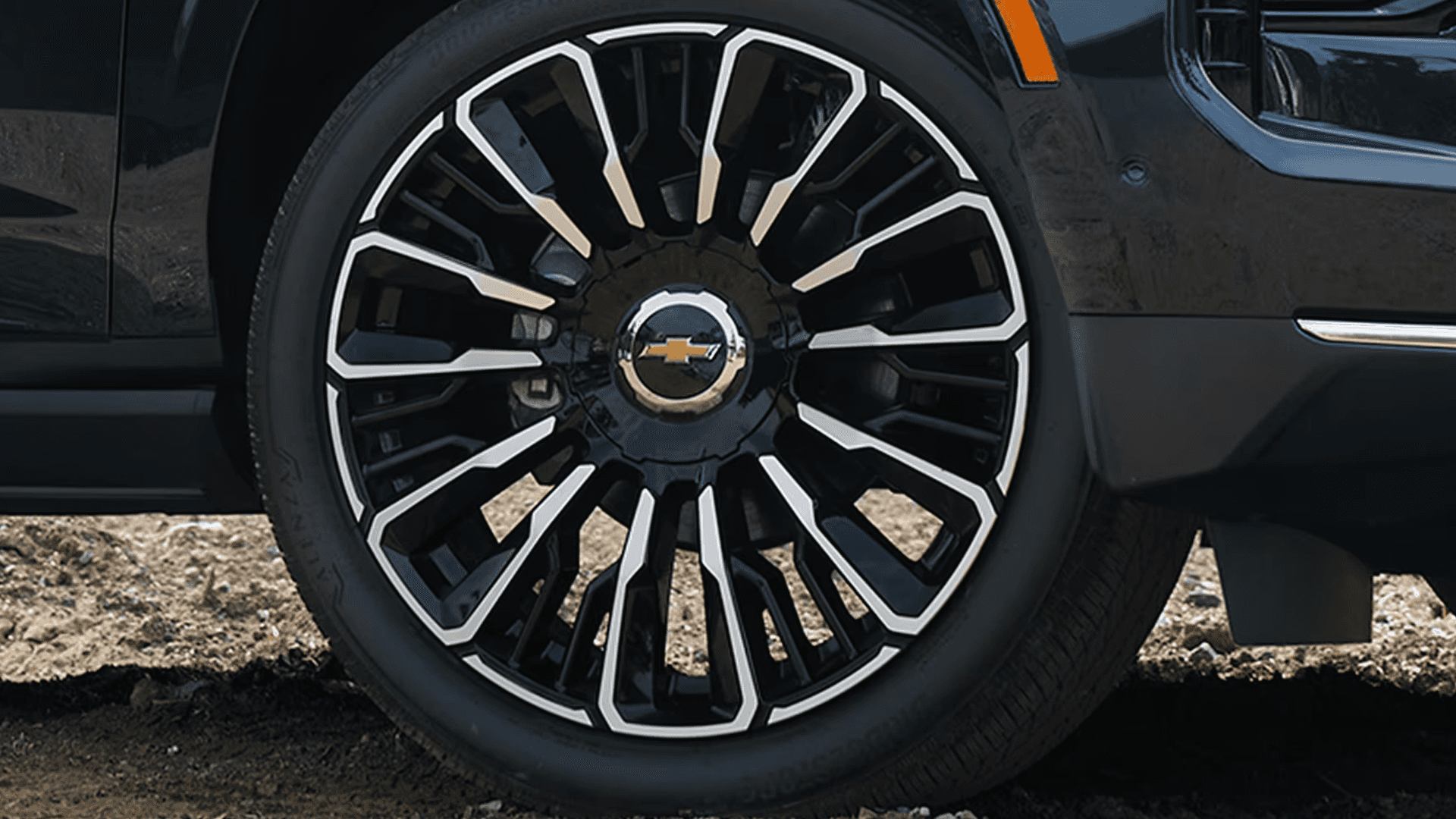 close up of a polished multi-spoke wheel and tire on a 2026 Chevrolet Tahoe with black finish and silver accents