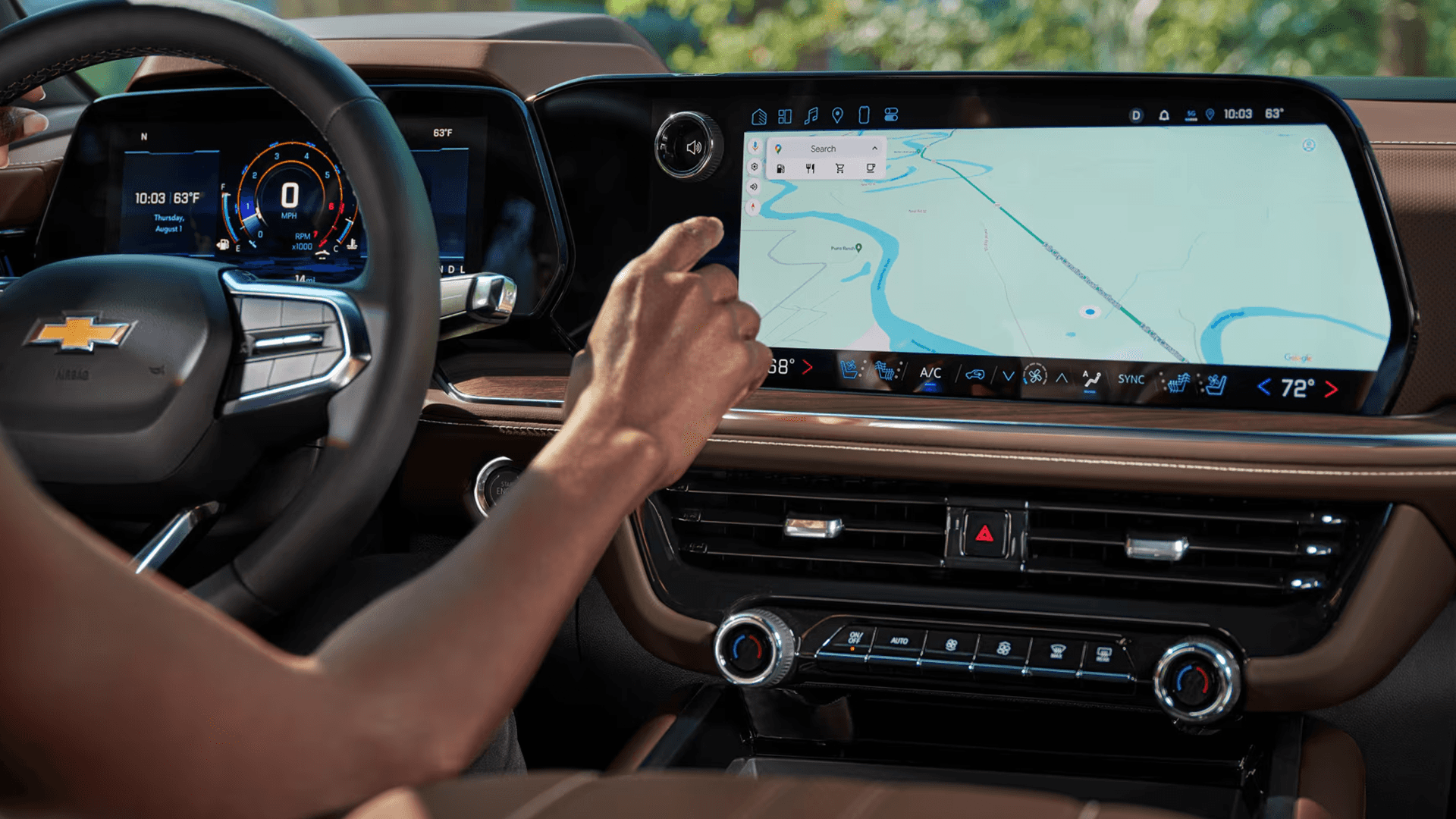 close up of the 2026 Chevrolet Tahoe interior showing the driver’s hand interacting with a wide infotainment touchscreen and digital driver display