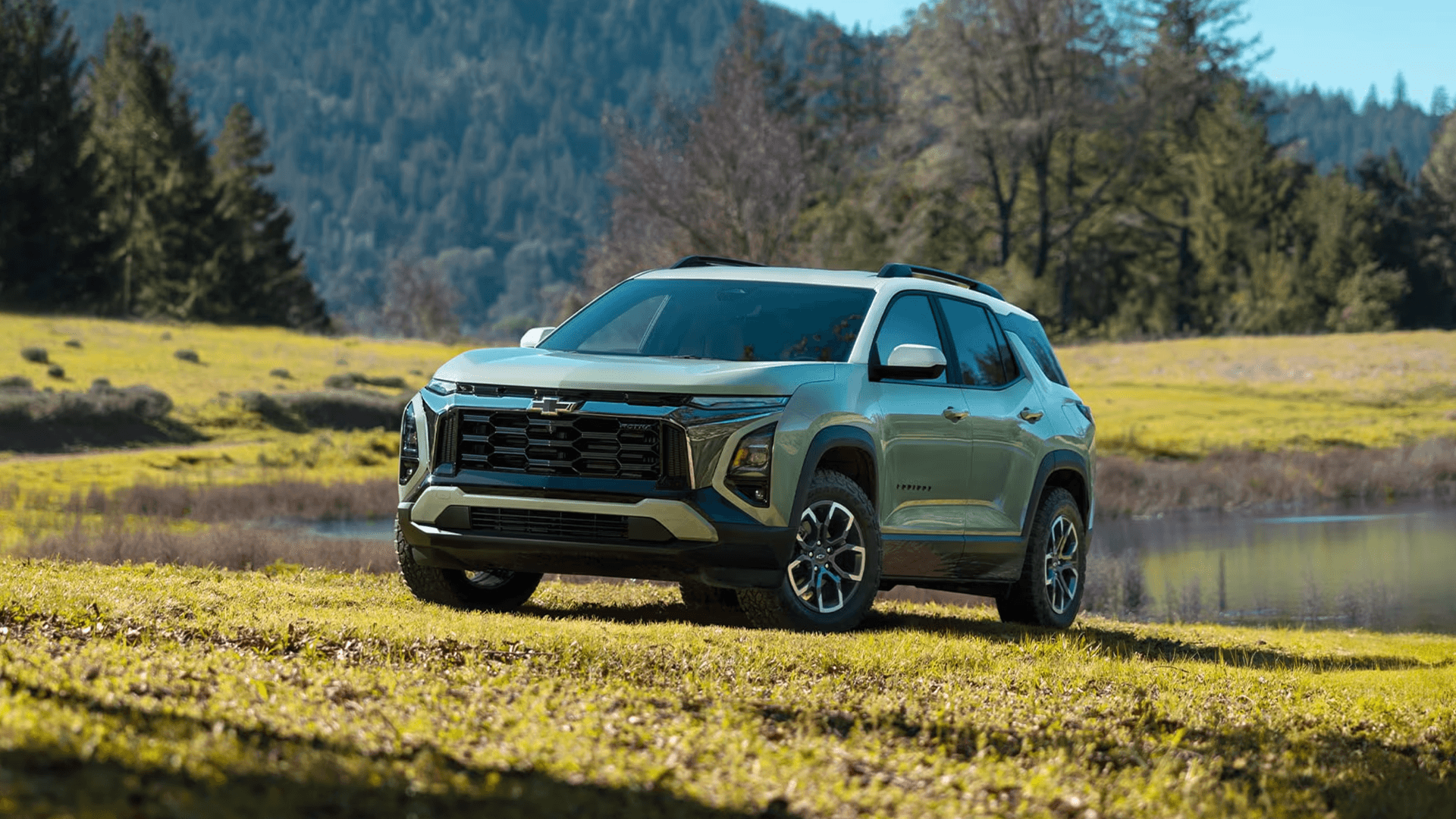 2026 Chevrolet Equinox Outdoor Capability 2026 Chevrolet Equinox parked on grass near water with mountains in the background
