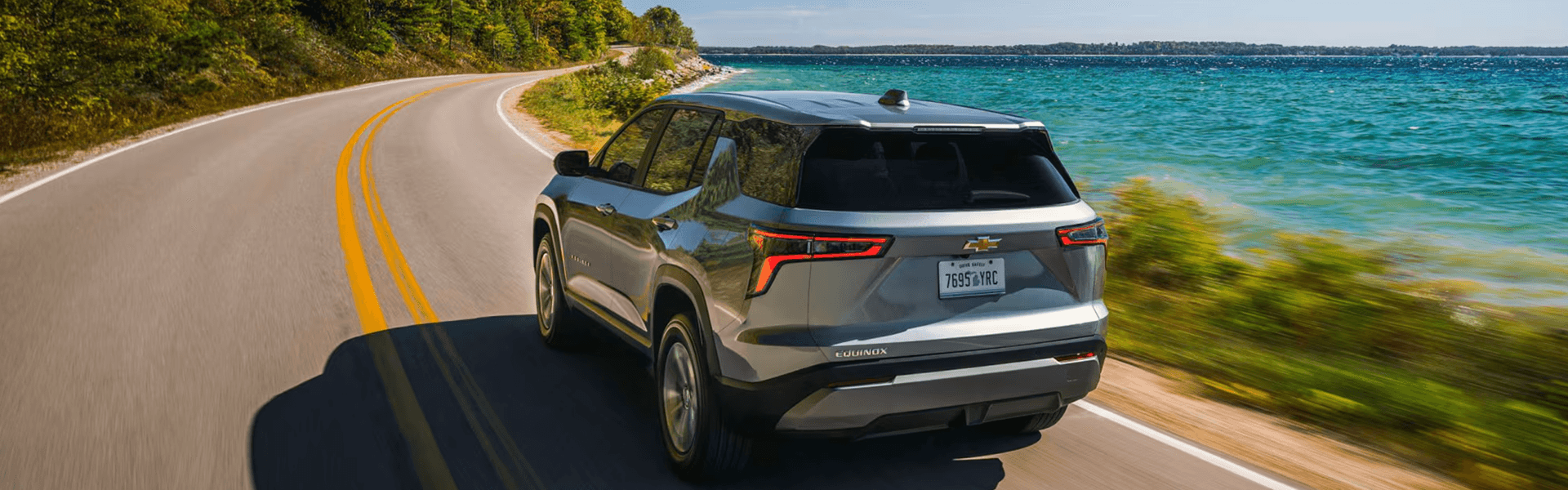 2026 Chevrolet Equinox driving along a scenic lakeside road