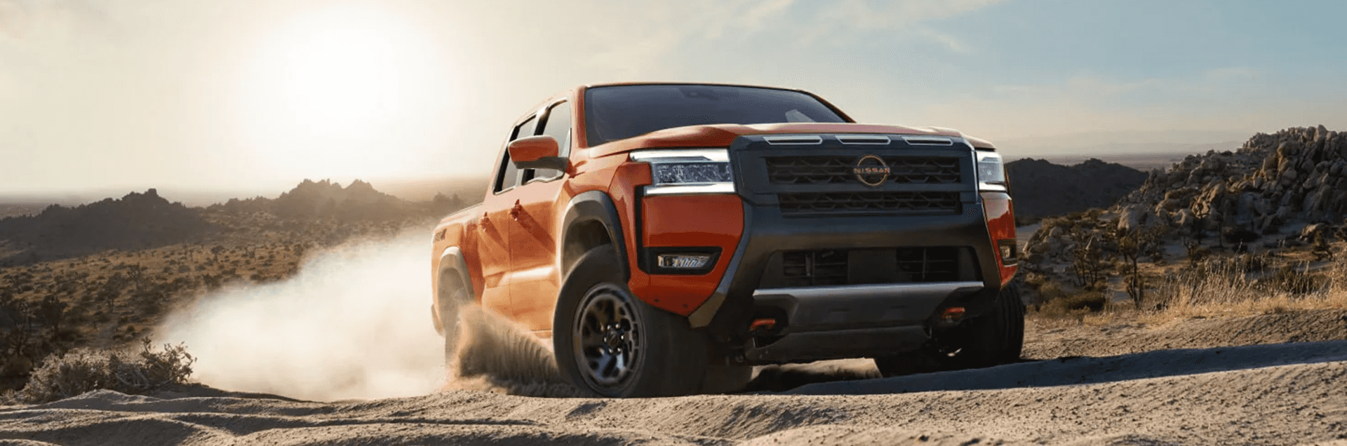 2026 Nissan Frontier driving off road at sunset