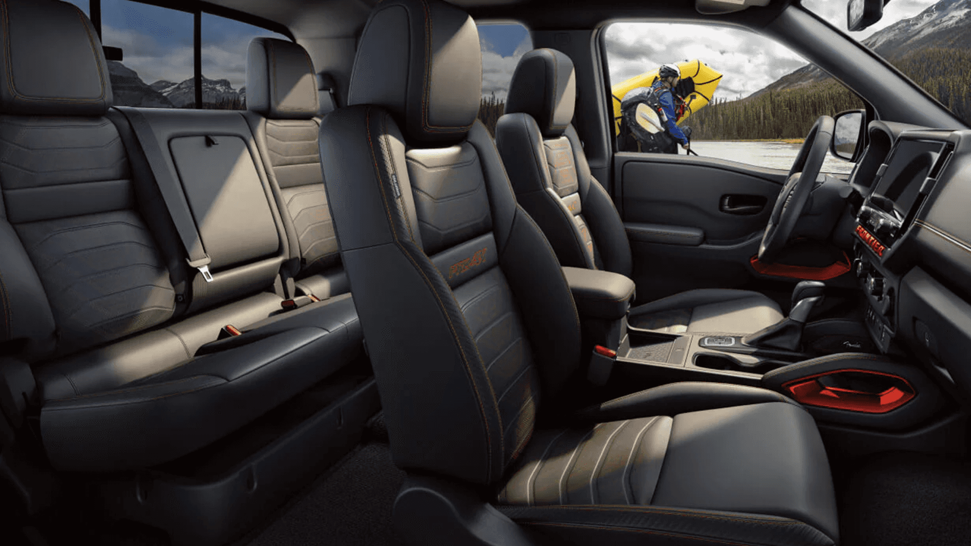2026 Nissan Frontier interior with front and rear seating, center console, and rugged cabin details for crew cab comfort