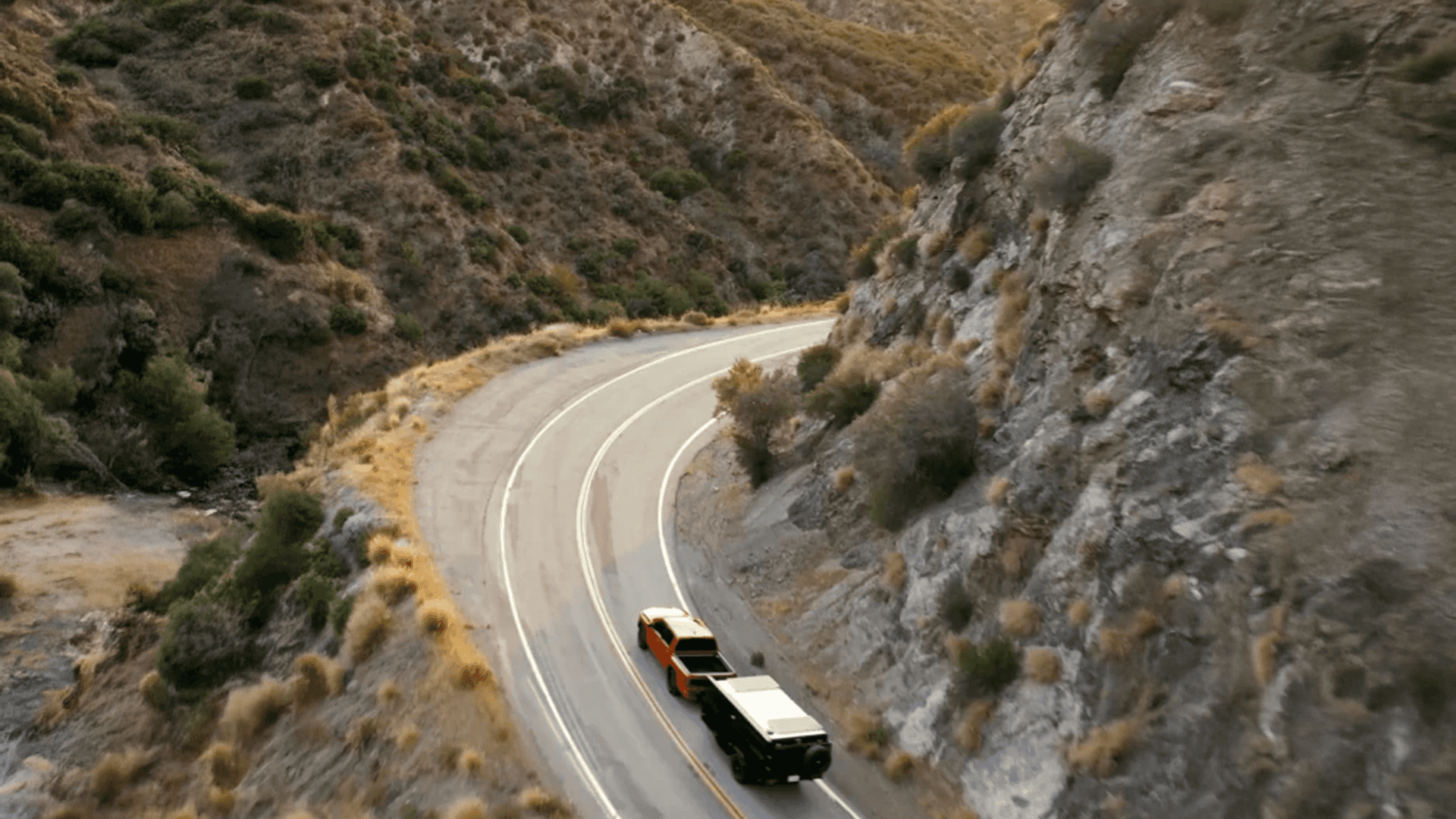2026 Nissan Frontier towing a trailer on a winding mountain road highlighting trailering and hauling capability