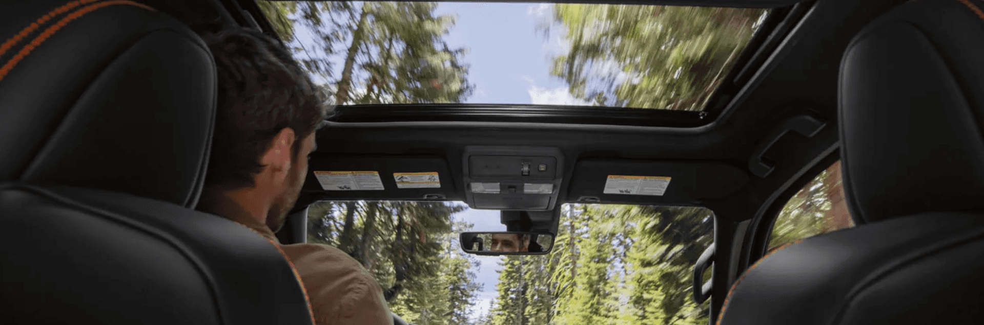 Nissan Frontier interior view looking forward through the windshield and moonroof toward the center touchscreen