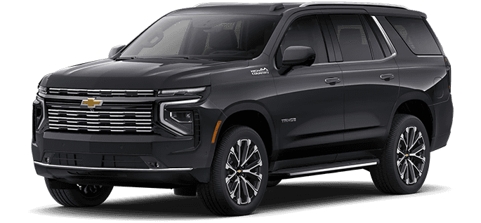 2026 Chevy Tahoe driving through a city street showing side profile and full size SUV design