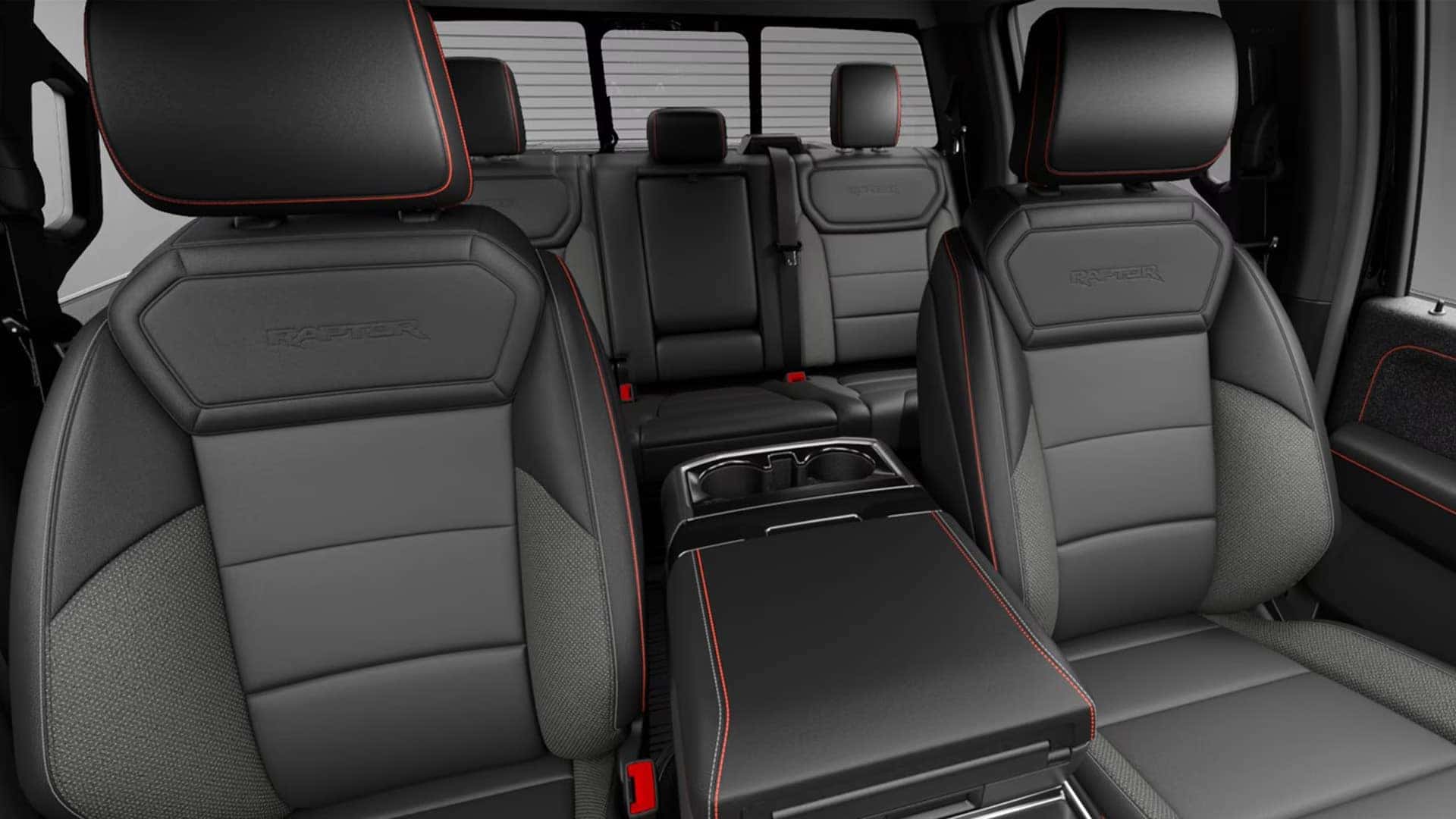 2026 Ford F-150 Raptor interior showing sport front seats, rear seating, and center console with bold contrast stitching