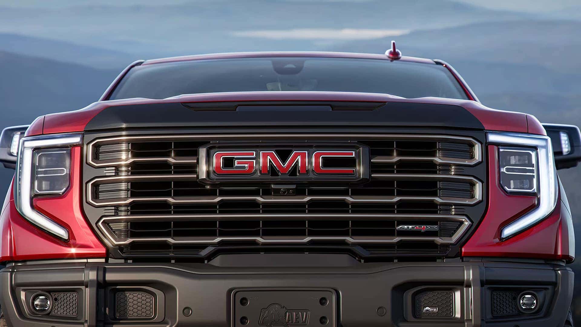 Front view of the 2026 GMC Sierra 1500 with LED signature lighting and illuminated grille design.