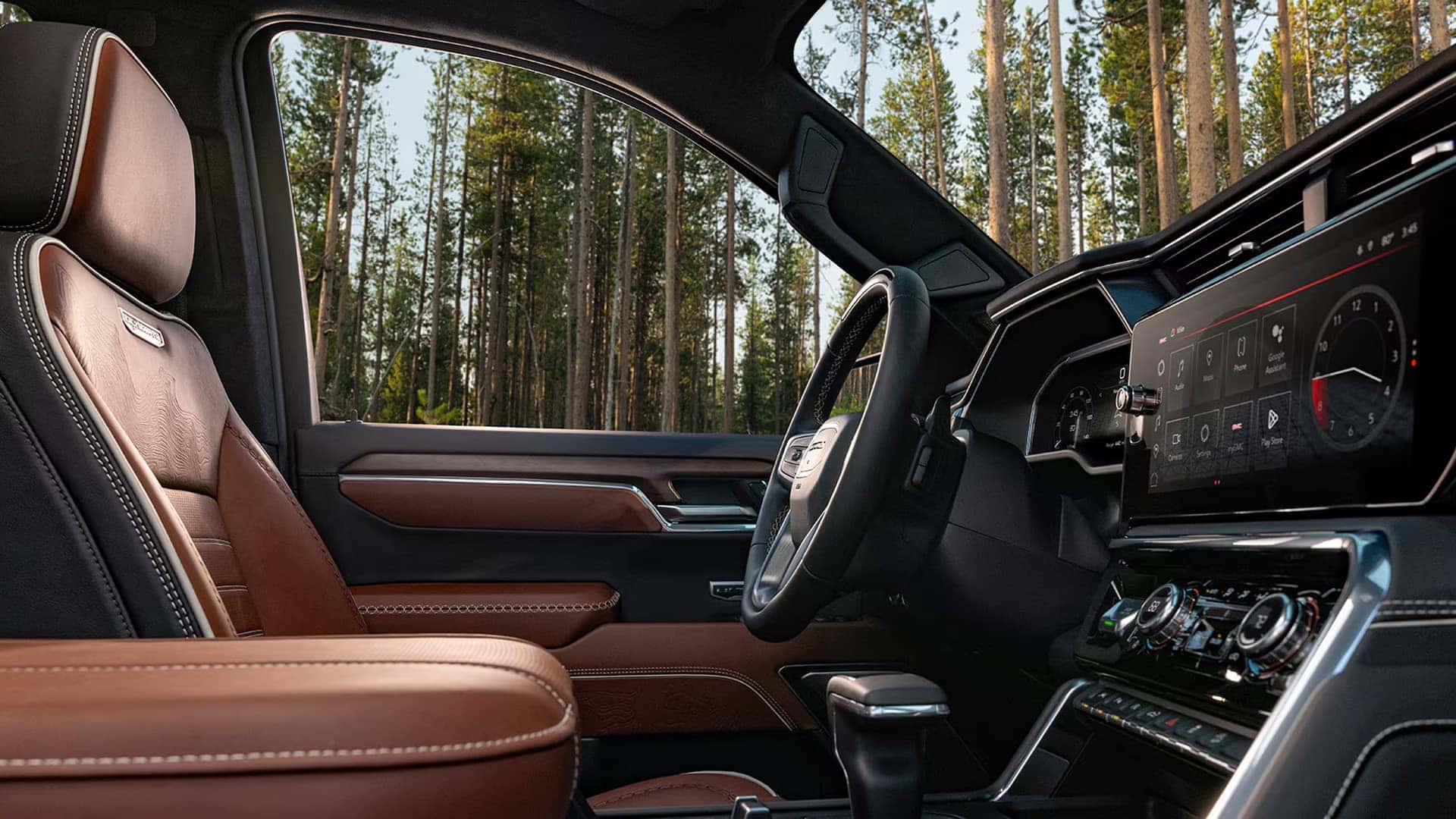 Interior of the 2026 GMC Sierra 1500 with premium brown leather seats, spacious front cabin, and refined materials.